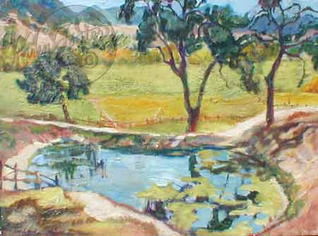 The blue green ranch pond is reflecting the trees and plant life that are surrounding it. The pastures on in the distance and the mountains are behind them.